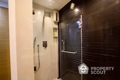 Modern bathroom with sleek glass shower and dark tile accents