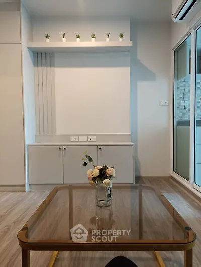 Modern living room with glass table and minimalist decor in stylish apartment.