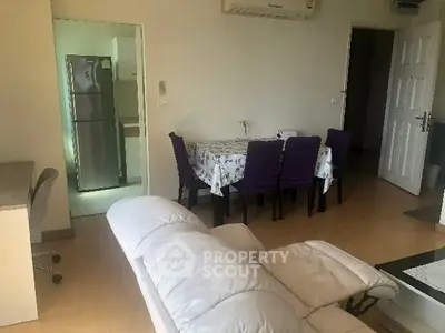 Cozy living room with dining area and modern kitchen in open layout apartment.