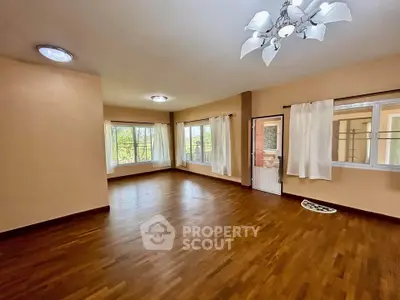 Spacious living room with hardwood floors and large windows offering natural light.