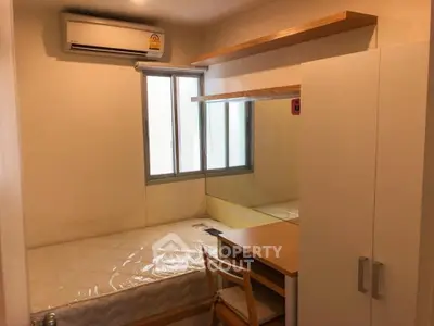 Cozy bedroom with built-in wardrobe and air conditioning in modern apartment.