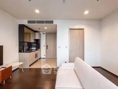 Modern living room with open kitchen layout and stylish furniture