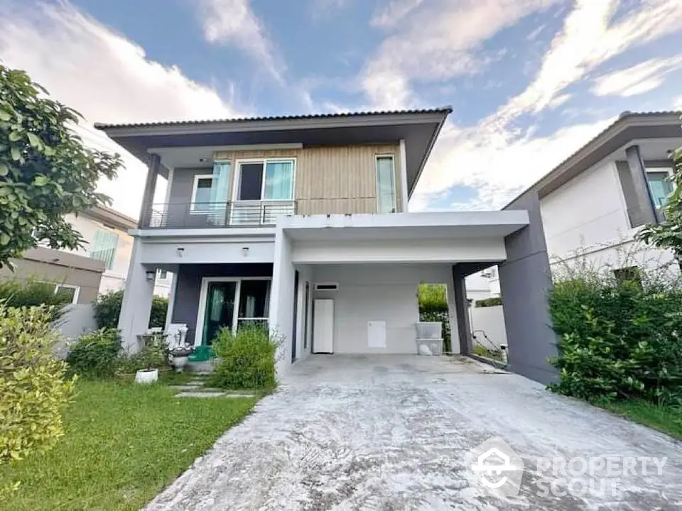 Modern two-story house with spacious driveway and lush garden