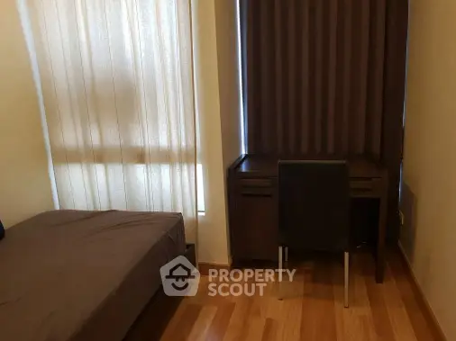 Cozy bedroom with wooden flooring and study desk, perfect for a comfortable living space.