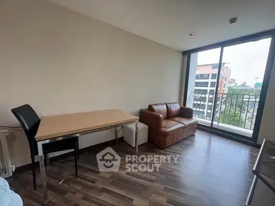 Modern living room with leather sofa and city view balcony, perfect for urban living.