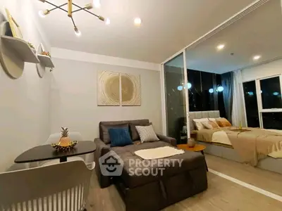 Modern living room with cozy seating and stylish decor adjacent to a chic bedroom.
