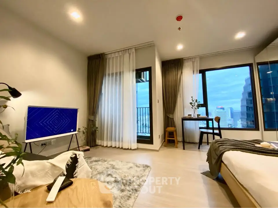 Modern living room with city view, featuring stylish decor and natural light.