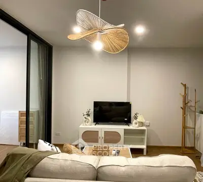 Modern living room with stylish decor and unique ceiling fan, featuring a cozy sofa and entertainment center.