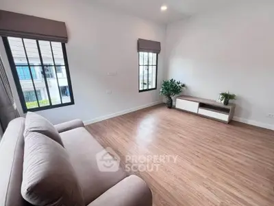 Spacious living room with modern decor and large windows offering natural light.