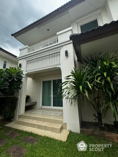 Charming two-story house with lush garden and elegant entrance