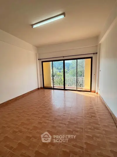 Spacious living room with large windows and scenic balcony view, perfect for natural light lovers.