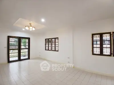 Spacious unfurnished living room with large windows and elegant lighting