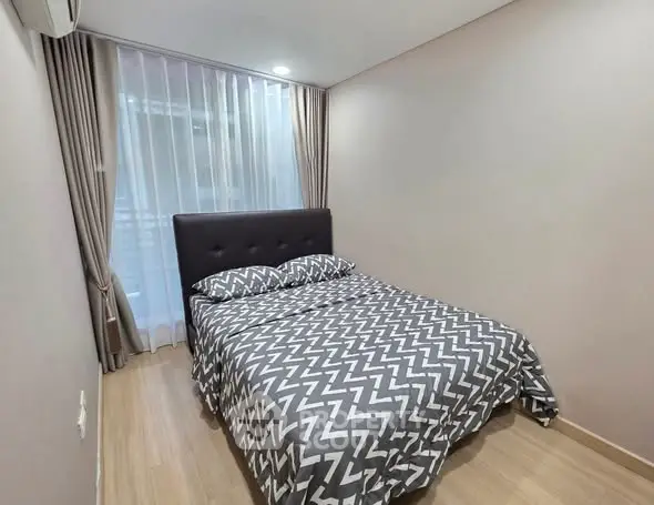 Cozy bedroom with modern decor and natural light, perfect for relaxation.