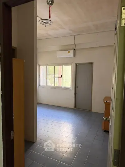 Spacious room with tiled floor and air conditioning, perfect for versatile use.