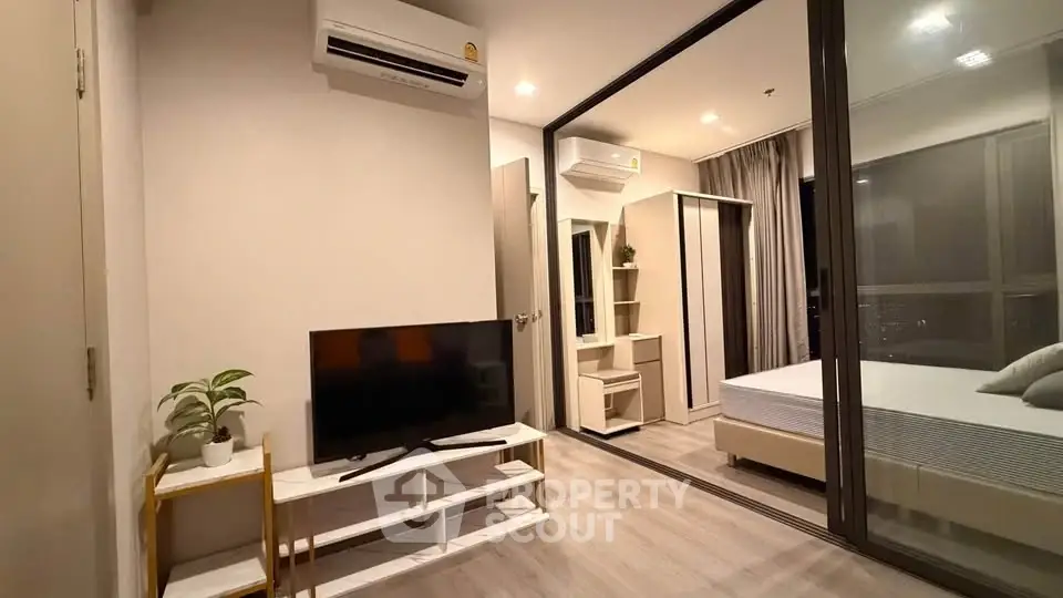 Modern apartment interior with living room and bedroom, featuring sleek design and ample natural light.