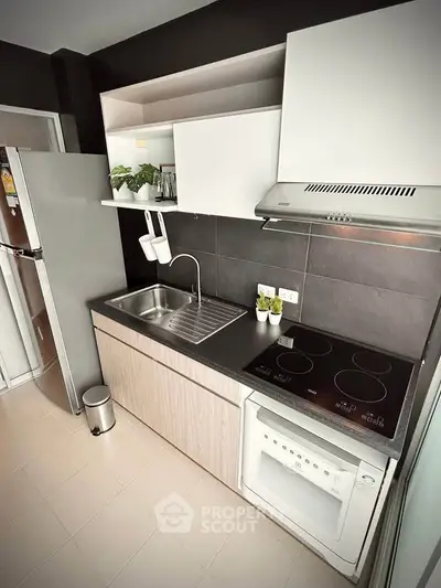 Modern kitchen with sleek cabinetry, electric stove, and built-in oven in a stylish apartment.