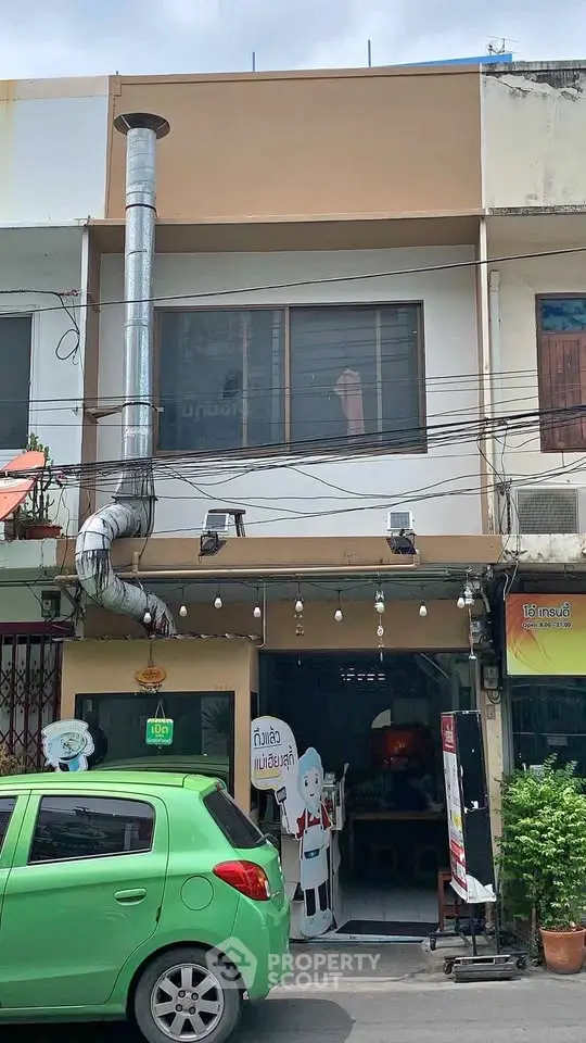 Charming commercial building with unique exterior pipe feature and street view.