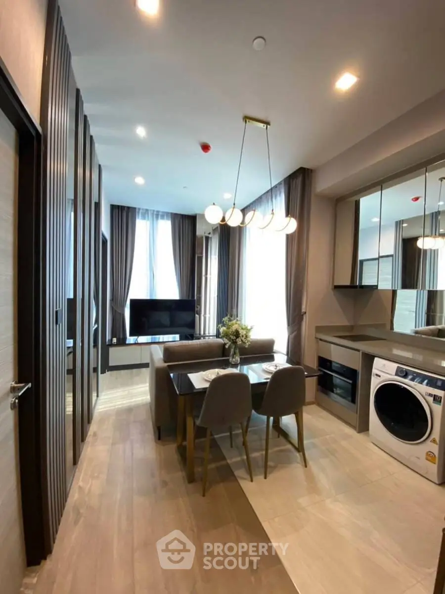 Modern open-plan living and dining area with stylish decor and in-unit washing machine.