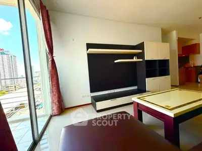 Spacious living room with modern furniture and large balcony offering city views.