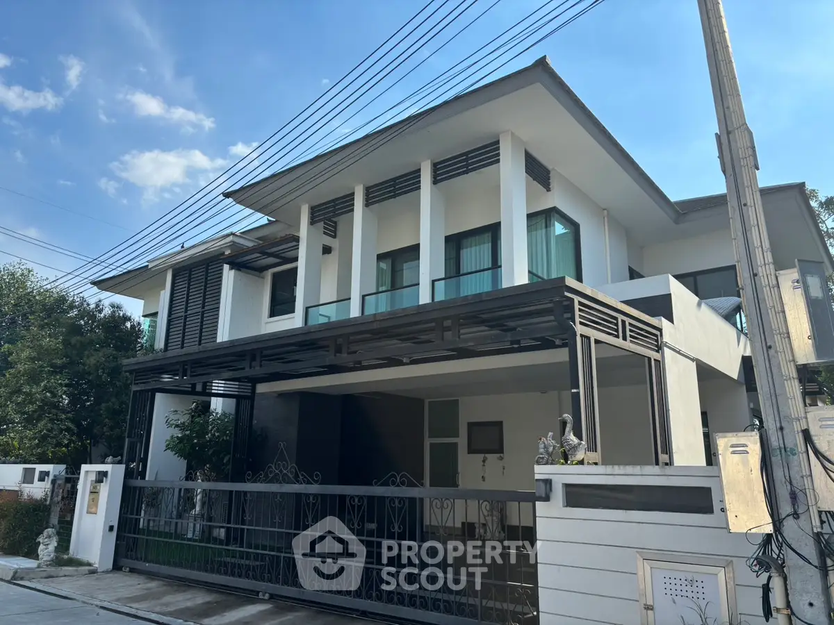 Modern two-story house with sleek design and spacious balcony in a serene neighborhood.