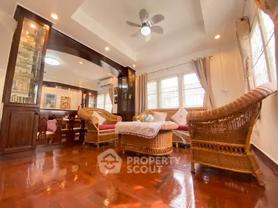 Charming living room with wicker furniture and polished wooden floors, perfect for cozy gatherings.