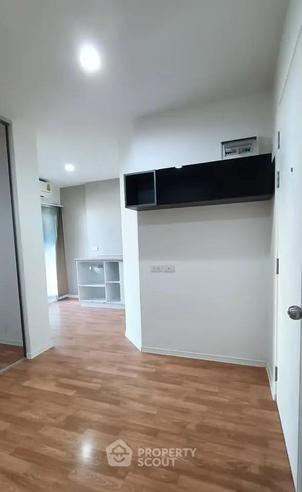 Modern apartment interior with wooden flooring and built-in shelving, ideal for urban living.