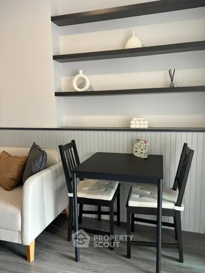 Chic modern living area with sleek black table and minimalist shelving.