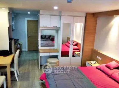 Cozy modern bedroom with stylish decor and ample storage in a compact apartment.