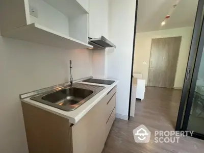 Modern compact kitchen with sleek cabinetry and induction cooktop in stylish apartment