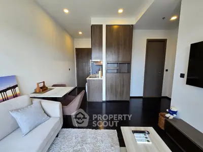 Modern living room with open kitchen layout, featuring sleek furniture and warm lighting for a cozy ambiance.