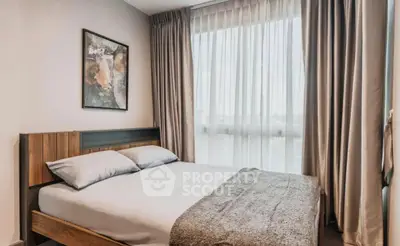 Cozy bedroom with modern decor and large window for natural light.