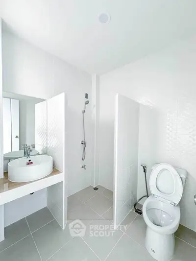 Modern bathroom with sleek white tiles and contemporary fixtures.