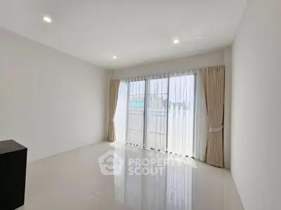 Spacious empty room with large windows and elegant curtains