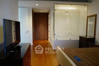 Modern bedroom with wooden flooring and glass partition