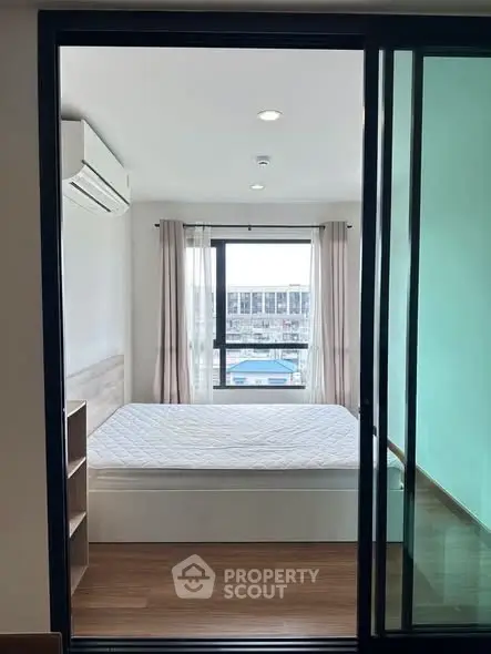Modern bedroom with large window and air conditioning in a stylish apartment.