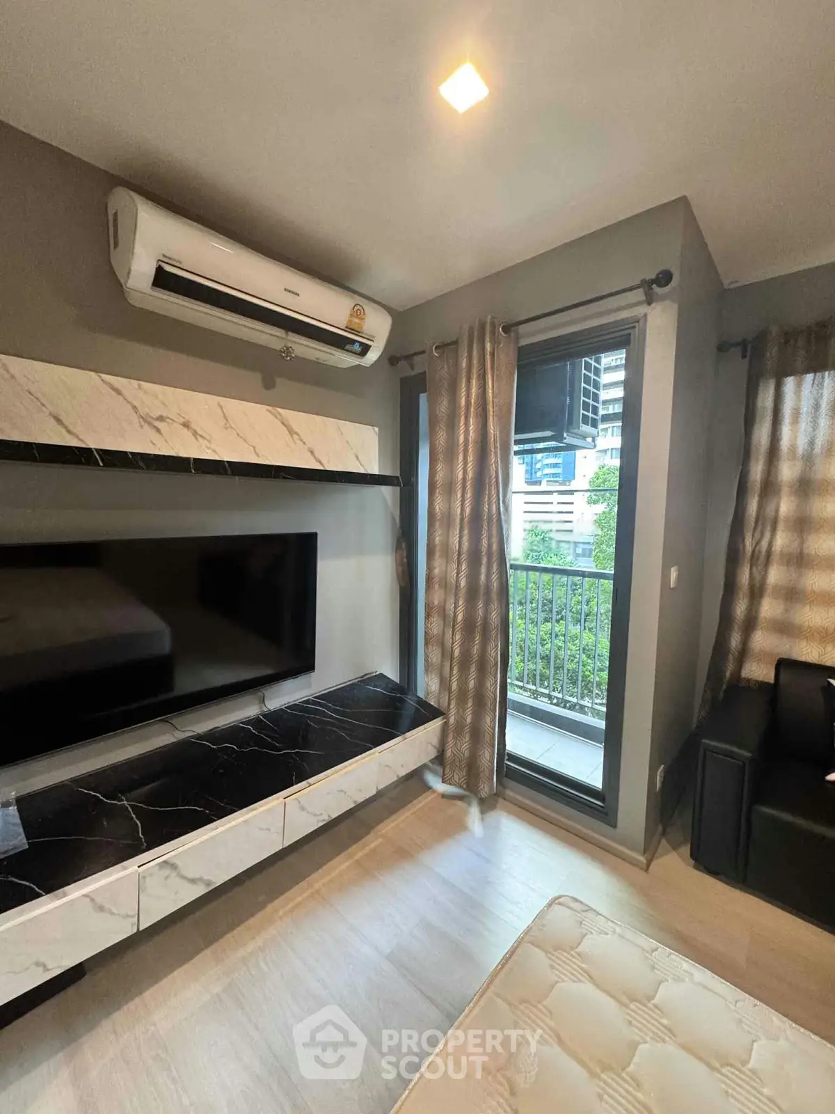 Modern living room with balcony view and sleek air conditioning unit