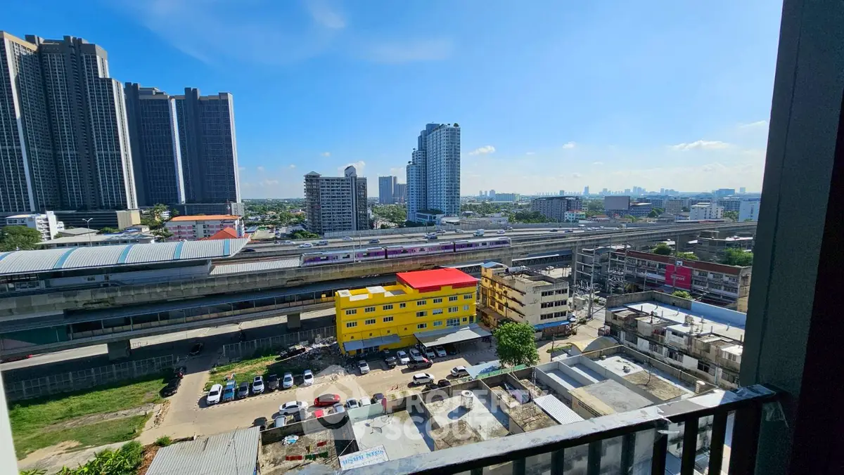 Stunning urban view from balcony overlooking city skyline and train tracks.