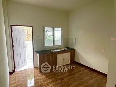 Spacious kitchen with modern sink and ample natural light, featuring a sleek closed layout.