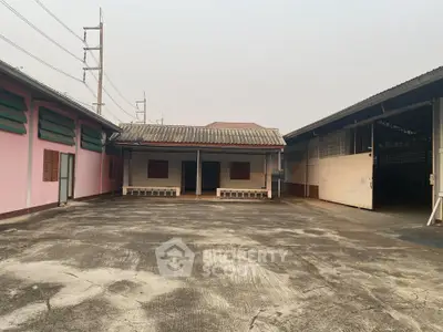 Spacious industrial property with large open courtyard and multiple warehouse buildings.