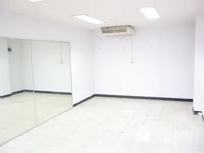 Spacious empty room with mirrored wall and air conditioning unit