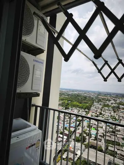 High-rise balcony with city view and air conditioning units, perfect for urban living.