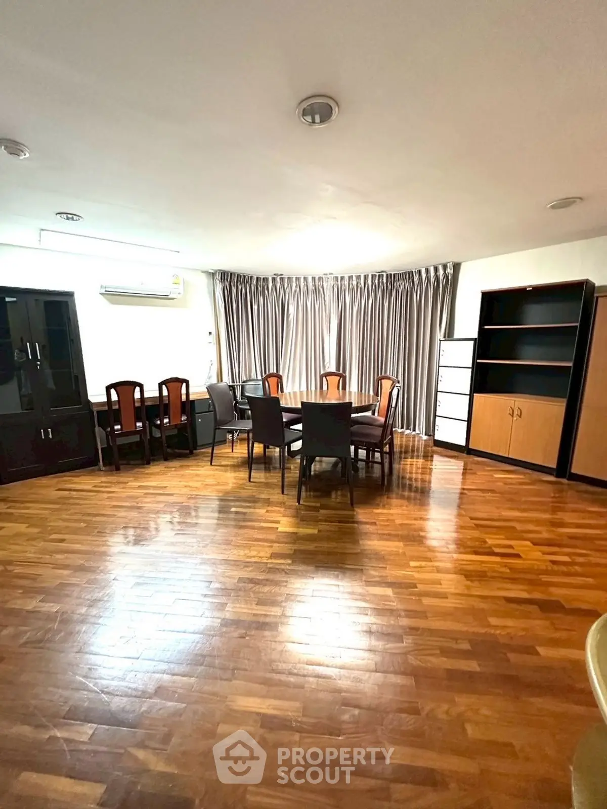 Spacious dining area with wooden flooring and elegant furniture, perfect for family gatherings.