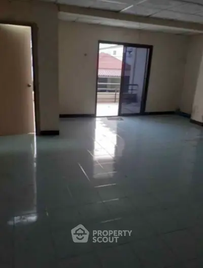 Spacious unfurnished room with tiled floor and balcony access, ideal for customization.