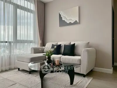 Elegant living room with modern sofa, large window, and stylish decor in a bright apartment.