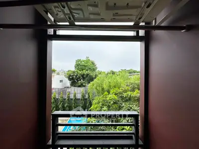 Scenic view from a modern balcony overlooking lush greenery and a pool, perfect for relaxation.