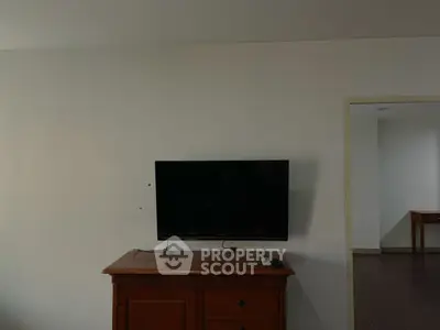 Minimalist room with wall-mounted TV and wooden cabinet, perfect for cozy living.