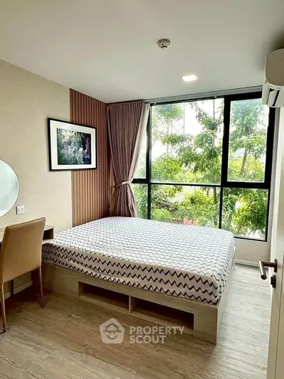 Modern bedroom with large window and stylish decor in a cozy apartment.