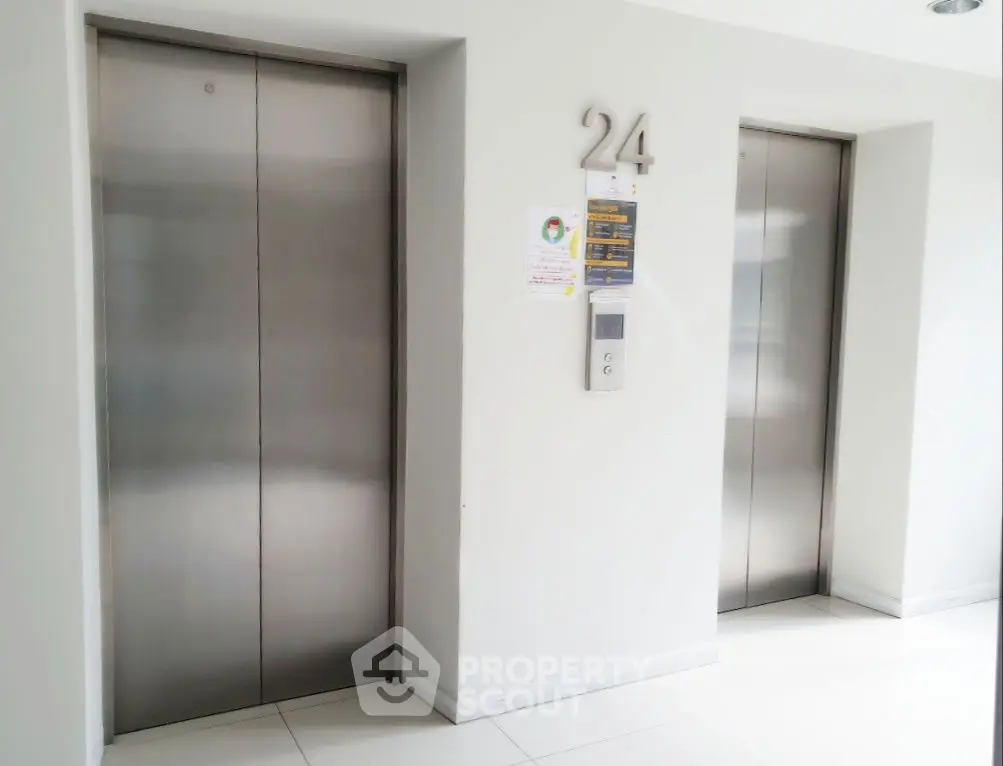 Modern building elevator lobby with two sleek elevators on the 24th floor.