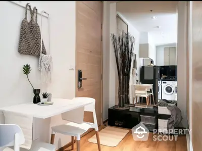 Modern apartment interior with stylish dining area and compact kitchen featuring washing machine.