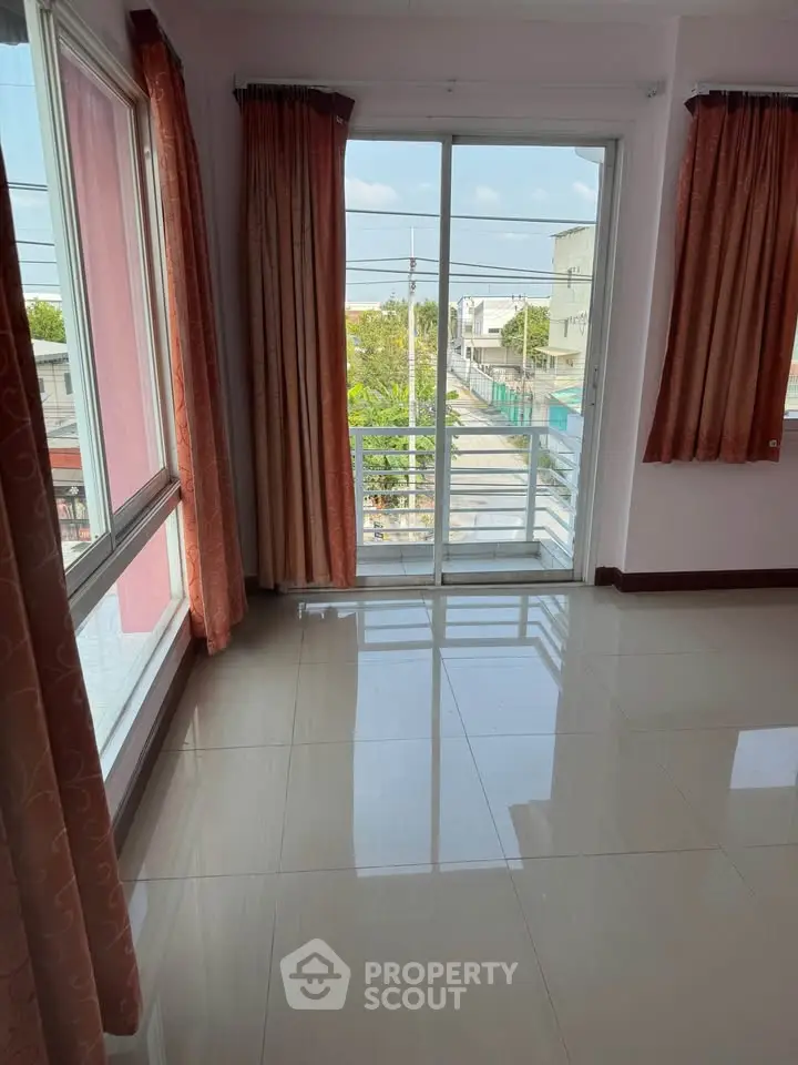 Spacious room with large windows and balcony offering a city view, perfect for natural light lovers.